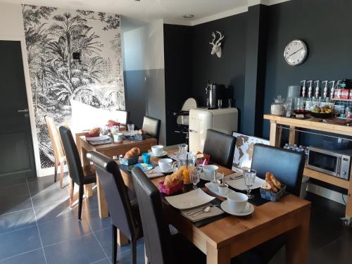 a dining room with a wooden table and chairs at La Grange in Savonnières