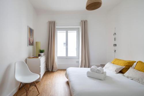 ein weißes Schlafzimmer mit einem weißen Bett und einem Fenster in der Unterkunft Harmonie by Cocoonr in Nantes