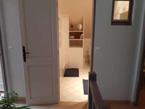 an open door to a hallway with a tile floor at La grange des lisières in Rouvres