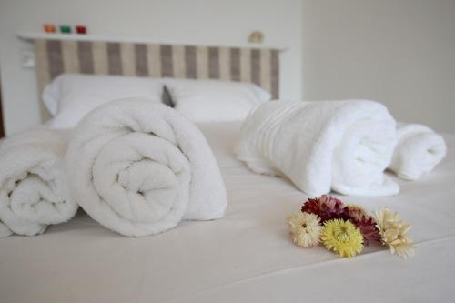a pile of towels and flowers on a bed at Departamento Céntrico con Vista in San Carlos de Bariloche