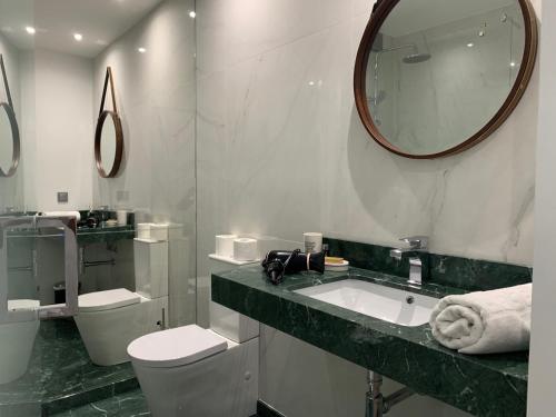 un bagno con lavandino, WC e specchio di Central - São Pedro Boutique a Funchal