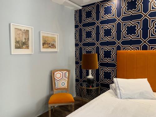 una camera da letto con un letto e una sedia di Central - São Pedro Boutique a Funchal