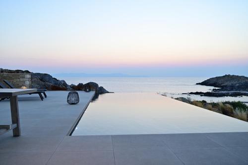a patio with a view of the ocean at Kavos Hotel & Suites in Stavros