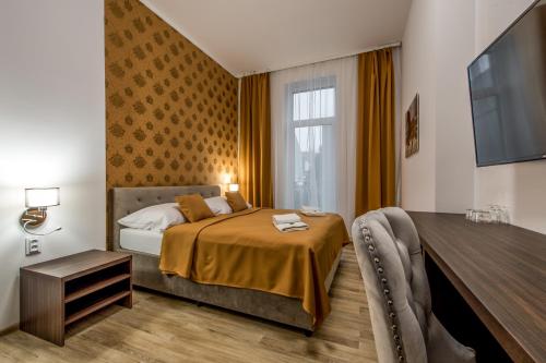 Dormitorio con cama, escritorio y TV en Hotel Black Horse, en Prešov