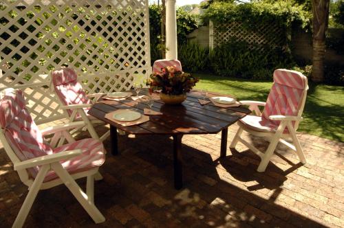 a table and four chairs on a patio at Braeview Guest House in Hermanus