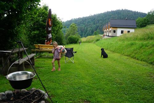 a girl standing in a field with a black dog at Rekreačna usadlosť Pieninka in Lesnica