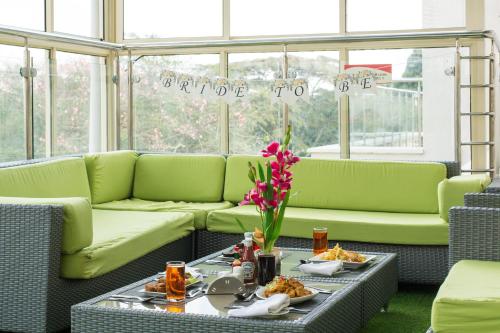 a room with green couches and a table with food at Executive Residency by Best Western Nairobi in Nairobi