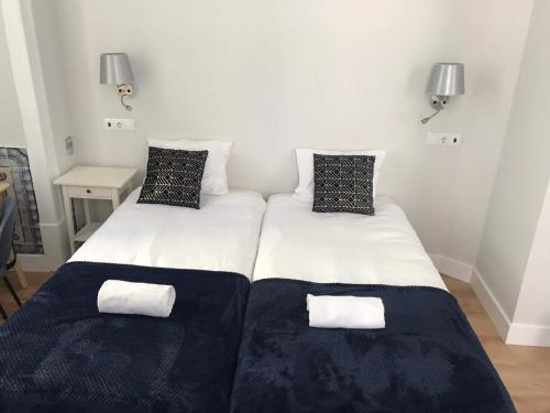 1 dormitorio con 2 camas y sábanas blancas y negras en Great Stay Fanqueiros 1, en Lisboa