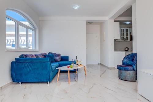 a living room with a blue couch and a table at Dolaca Villas in Sutomore