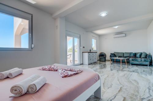 a bedroom with a large pink bed with towels on it at Dolaca Villas in Sutomore