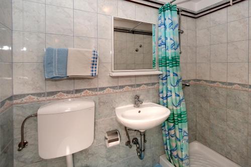 Mihaela Apartments في بوريتش: حمام مع حوض ومرحاض ومرآة