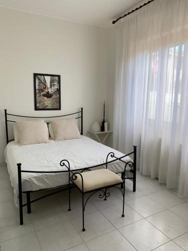 a bedroom with a bed and a chair and a window at Casa Ohana in Serramanna