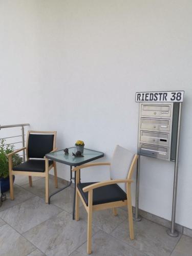 a table and two chairs and a sign on a wall at Haus Stegmeir in Hohenweiler