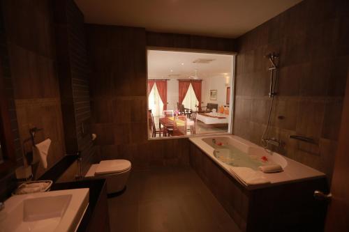 希卡杜瓦的住宿－希卡杜瓦清新酒店，带浴缸、卫生间和镜子的浴室