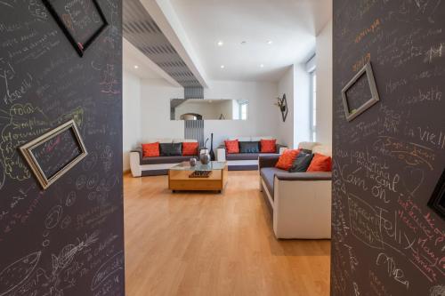 a living room with a wall with writing on it at Le Félix Grat - LAVALOC in Laval