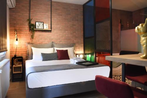 a bed in a room with a brick wall at Q Luxury Rooms in Thessaloniki