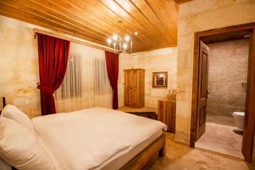 a bedroom with a large bed and a bathroom at ikarus Cappadocia Hotel in Uchisar