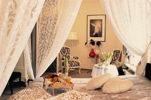 a bedroom with a bed with curtains and a table at Hotel Simonis in Kobern-Gondorf