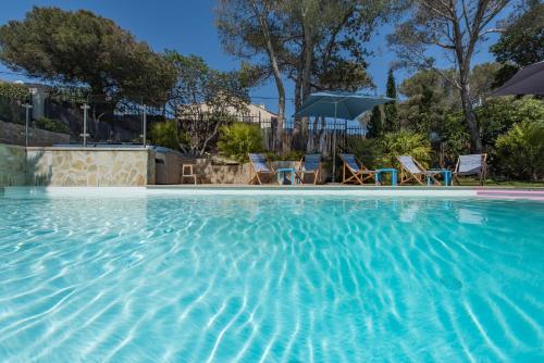 a swimming pool with chairs and umbrellas at Villa Perle De La Mer in Saint-Aygulf