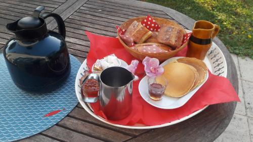 een tafel met een bord eten en een theepot bij La Licorne in Lamarche-sur-Saône