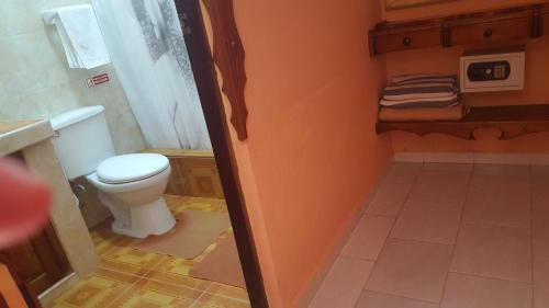 a small bathroom with a toilet and a sink at Casa El pescador in Playa Larga