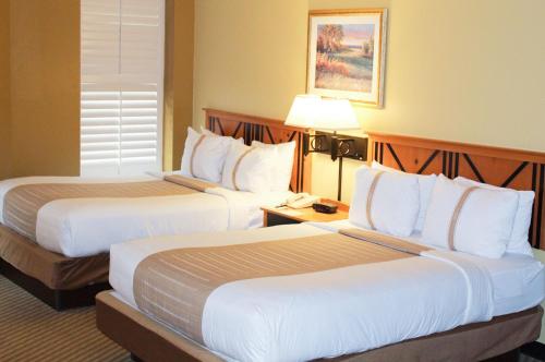 a hotel room with two beds and a lamp at The Crockett Hotel in San Antonio