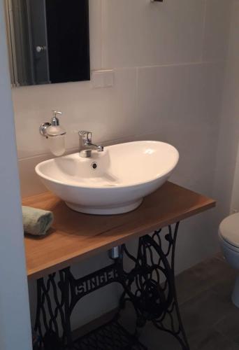 a white sink on a wooden counter in a bathroom at Pokoje Gościnne Karkonosze in Wojcieszyce