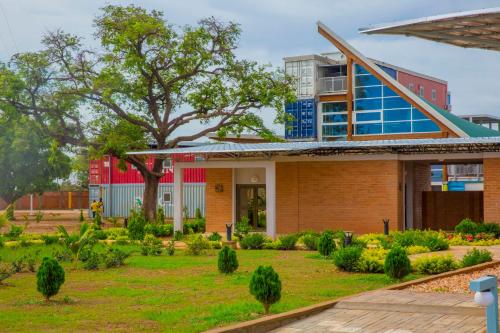 a house with a garden in front of it at Dunia Hôtel Ouagadougou Loumbila in Loumbila