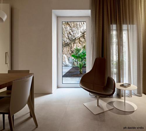 a living room with a chair and a table and a window at Hotel Villa Belvedere in Taormina