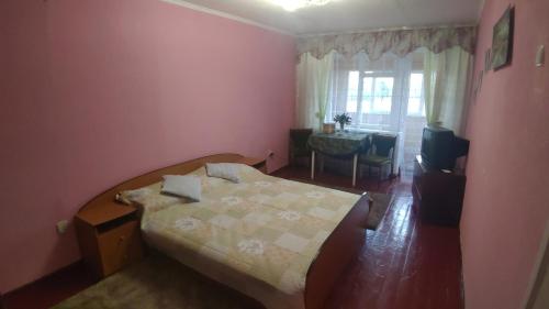 Uzynにあるквартира на вулиці Лесі Українкиのベッドルーム1室(ベッド1台、テーブル、窓付)