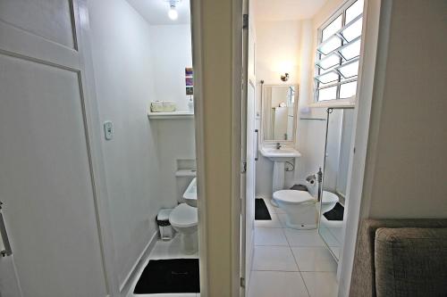 La salle de bains est pourvue de toilettes, d'un lavabo et d'une fenêtre. dans l'établissement Rio Spot Homes C048., à Rio de Janeiro