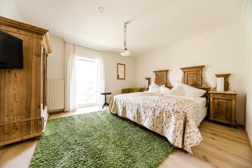 ein Schlafzimmer mit einem Bett mit einem grünen Teppich in der Unterkunft Hotel St. Hubertushof in Bad Gleichenberg