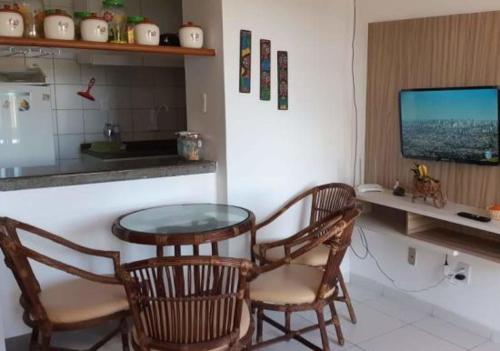 a kitchen with a table and two chairs and a television at Apartamento em frente Mar in Salvador