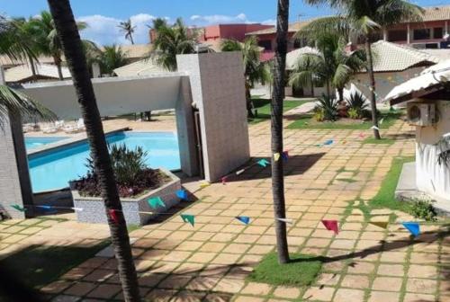 a resort with a swimming pool and palm trees at Apartamento em frente Mar in Salvador