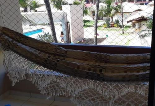 a wooden boat hanging on a fence near a pool at Apartamento em frente Mar in Salvador