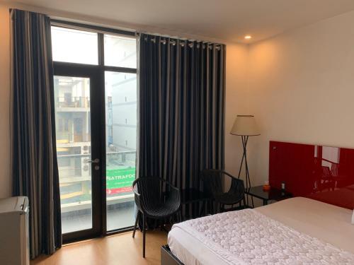 a hotel room with a bed and a large window at Gia Huyền Hotel in Ho Chi Minh City