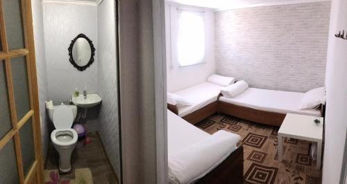 Comfort Guest House في بوروفوي: حمام صغير بسريرين ومرحاض