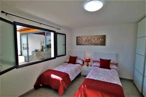 1 dormitorio con 2 camas y ventana en Holiday House and Spa Lanzarote, en Tías