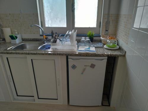 eine Küche mit einer Spüle und einer Arbeitsplatte in der Unterkunft Casa da avó Lu in Olhão