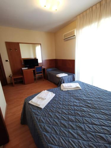 a hotel room with a bed with towels on it at Hotel Calgary in Casalbordino