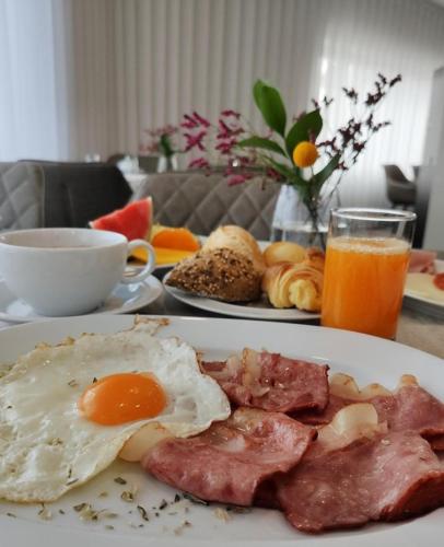 a plate of breakfast food with eggs bacon and meat at Mafra Hotel in Mafra