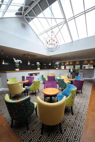 a lobby with colorful chairs and tables at Rossett Hall Hotel in Rossett