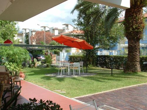 a patio with a table and chairs and an umbrella at Hotel Marina in Marina di Massa