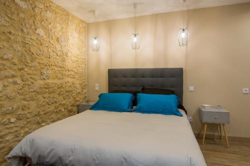 a bedroom with a large bed with blue pillows at B&B Les Marchettes in Saint-Nexans