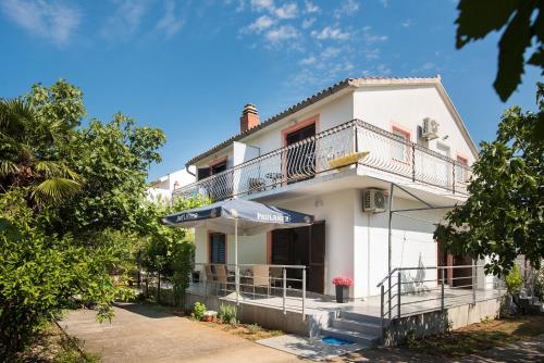 Cette maison blanche dispose d'un balcon. dans l'établissement Apartmani Jadranka, à Vodice