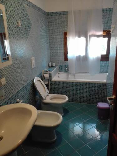 a bathroom with two toilets and a tub and a sink at Il posto del ciliegio selvatico in Cavaliere