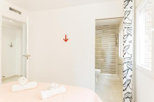 bagno bianco con letto e specchio di Suite Homes La Victoria a Málaga
