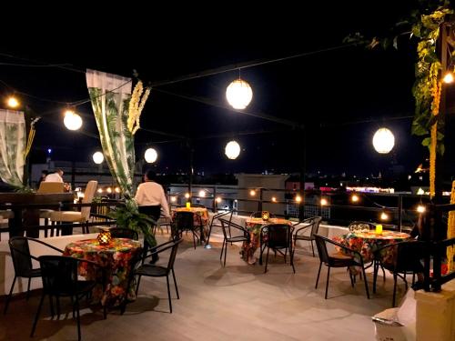 a patio with tables and chairs at night at Hotel Boutique Casa del Jardín Aguascalientes in Aguascalientes