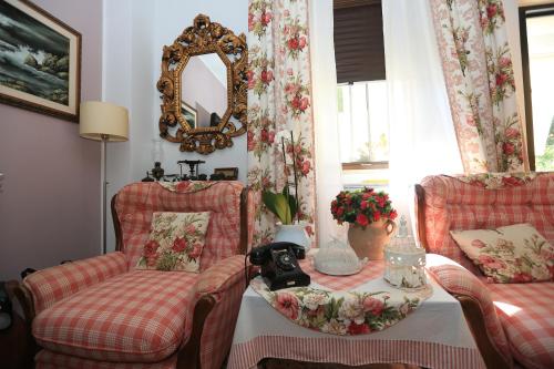 sala de estar con 2 sillas, mesa y espejo en B&B La casa di g.g., en Grottammare