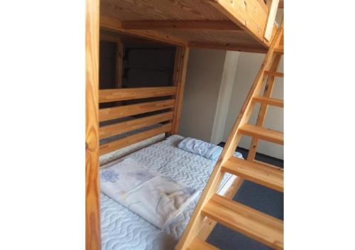 a bunk bed with a ladder in a room at Hidamarinoyu mix dormitory / Vacation STAY 40392 in Takayama